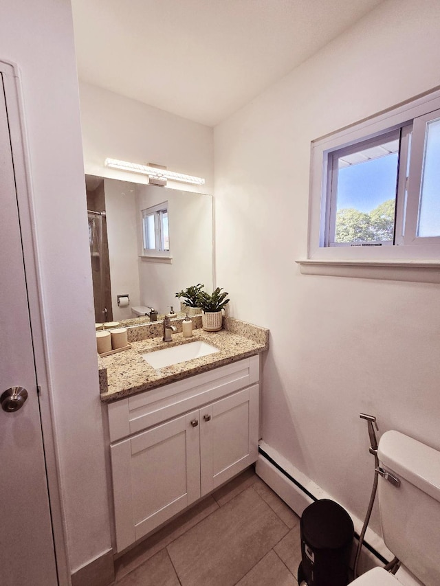 bathroom with baseboard heating, tile patterned floors, vanity, and toilet