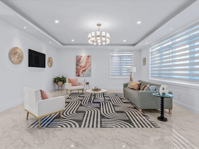 living room featuring a raised ceiling and a chandelier