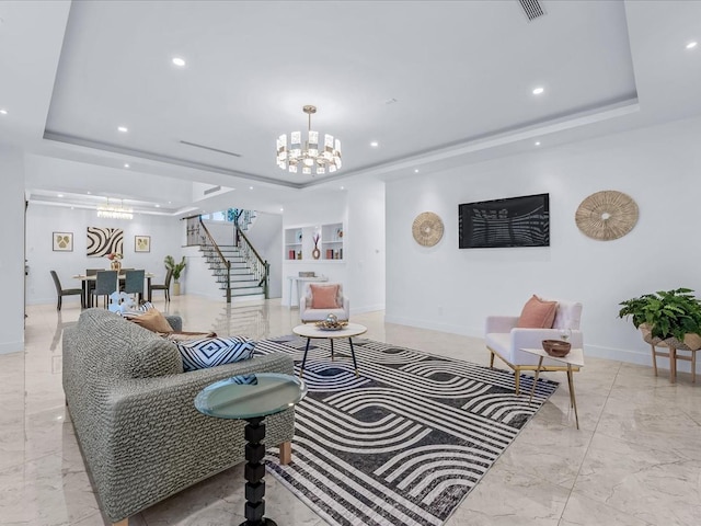 living room with a raised ceiling, built in features, and a notable chandelier