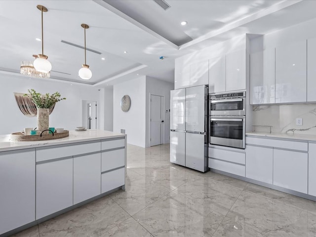 kitchen with white cabinets, a raised ceiling, and stainless steel appliances