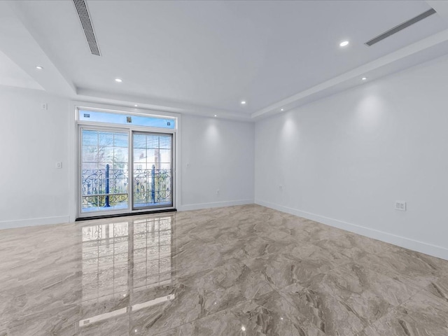 spare room with a tray ceiling