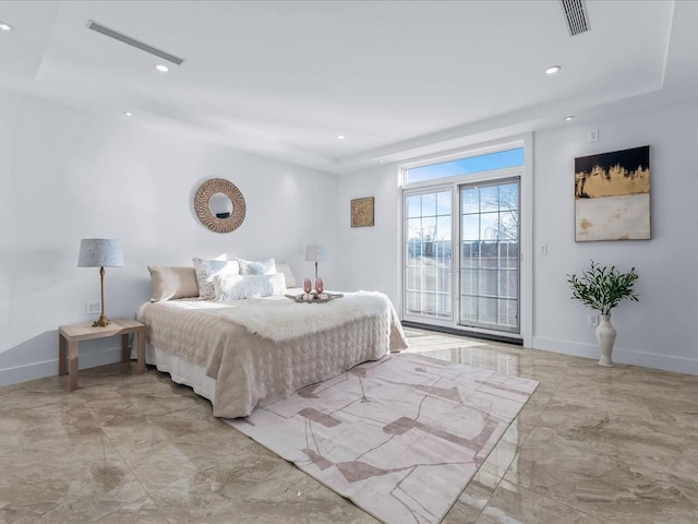 bedroom with a raised ceiling and access to exterior