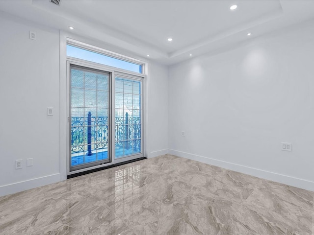 spare room with a raised ceiling