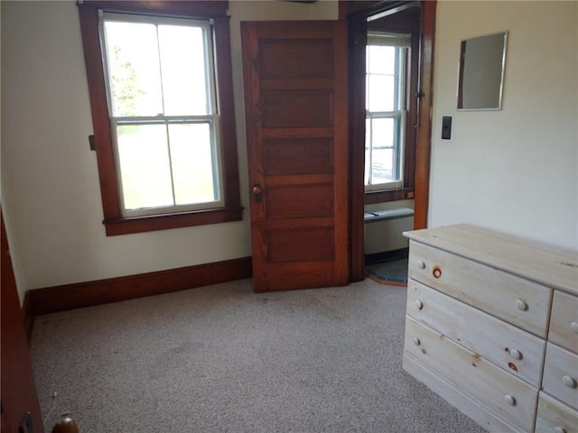 unfurnished bedroom featuring light colored carpet and multiple windows