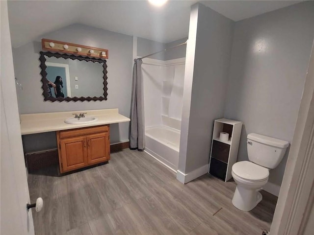 full bathroom featuring hardwood / wood-style floors, vanity, shower / bath combination with curtain, and toilet