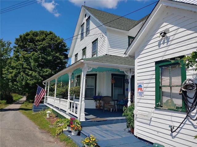 view of side of home featuring covered porch