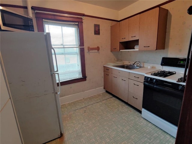 kitchen featuring sink, white appliances, and light brown cabinets