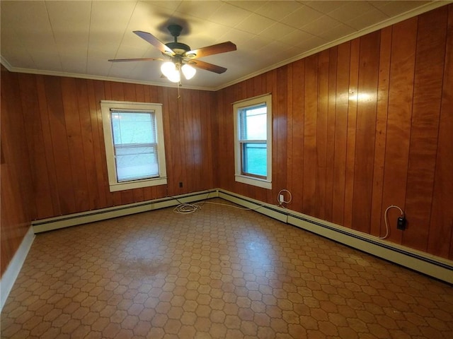 spare room with wood walls, ceiling fan, and ornamental molding