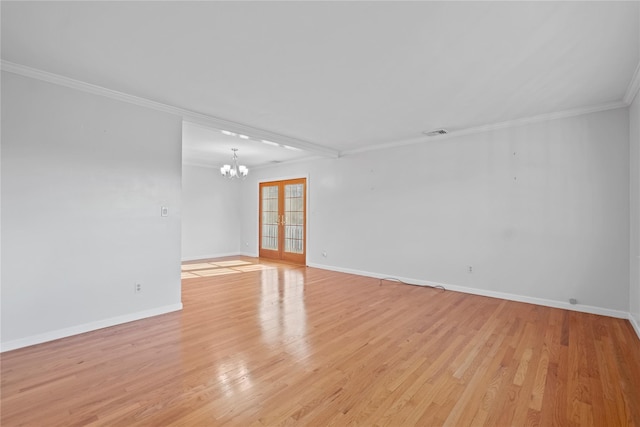 spare room featuring light hardwood / wood-style flooring, crown molding, and a chandelier