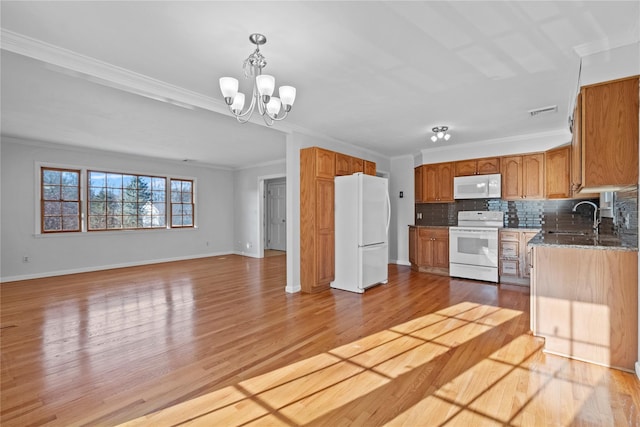 kitchen with sink, a notable chandelier, crown molding, white appliances, and decorative backsplash