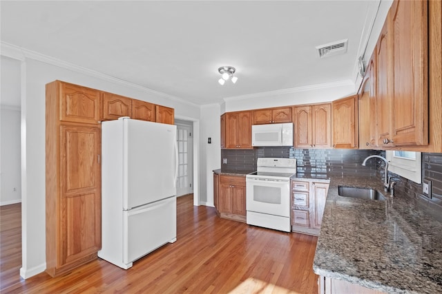 kitchen featuring light wood-type flooring, backsplash, white appliances, crown molding, and sink