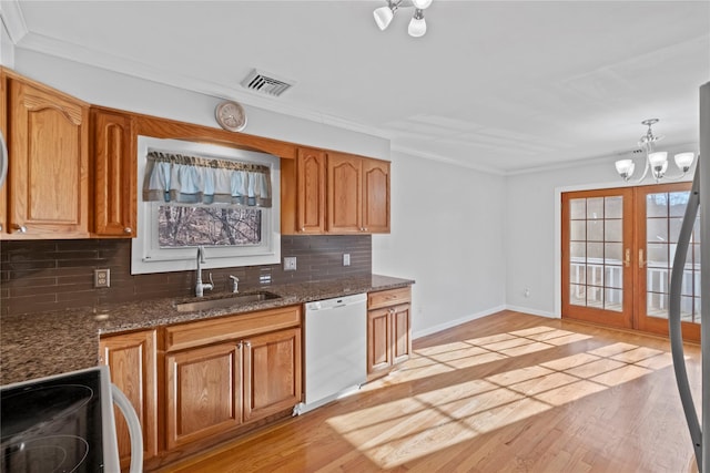 kitchen featuring sink, dishwasher, french doors, an inviting chandelier, and range