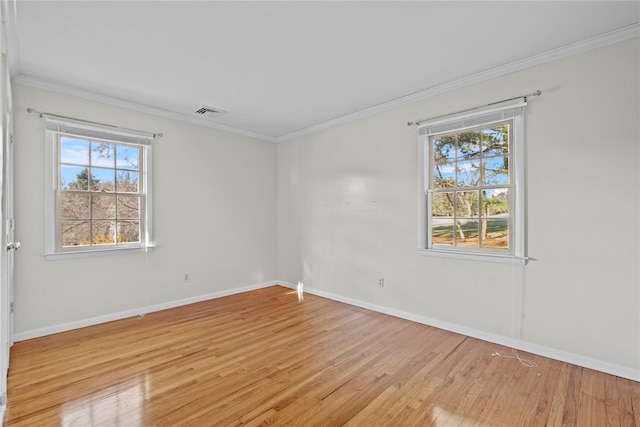 spare room with light wood-type flooring, a wealth of natural light, and crown molding