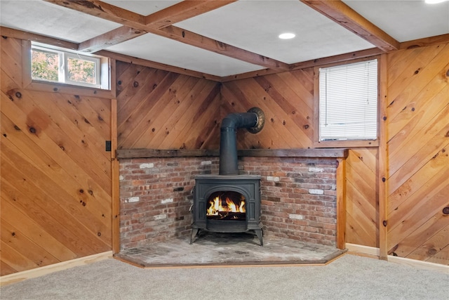 details with a wood stove, wood walls, beamed ceiling, and carpet