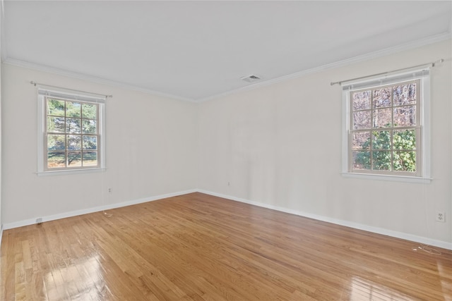 spare room featuring ornamental molding and light hardwood / wood-style flooring