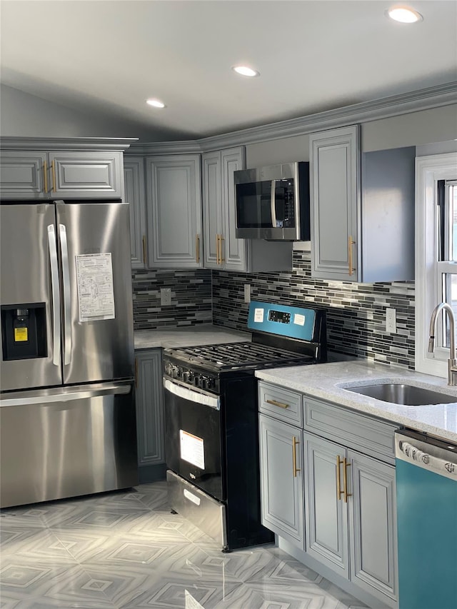 kitchen featuring gray cabinets, light stone counters, sink, and stainless steel appliances