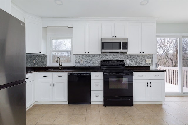 kitchen with white cabinetry, a healthy amount of sunlight, sink, and black appliances