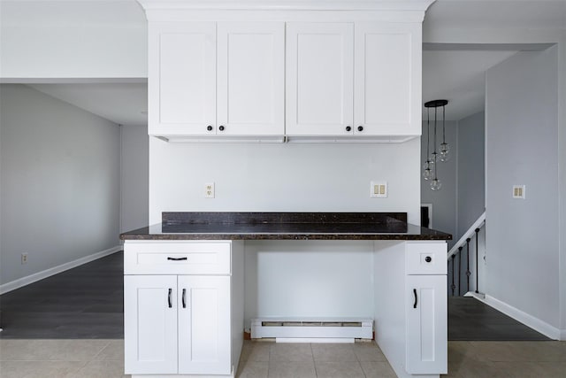 kitchen with baseboard heating, white cabinetry, light hardwood / wood-style flooring, and dark stone counters