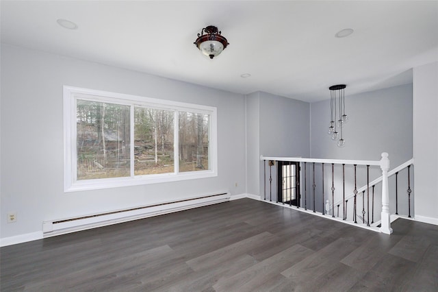 spare room featuring dark hardwood / wood-style floors and a baseboard heating unit