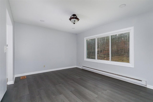 empty room with dark hardwood / wood-style floors and a baseboard radiator