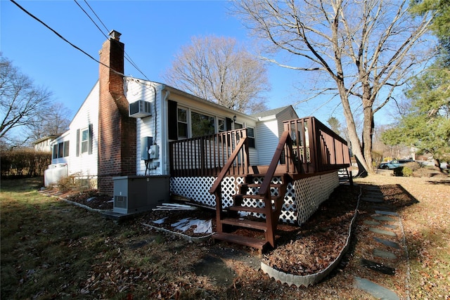 back of property featuring a wooden deck and a wall mounted air conditioner