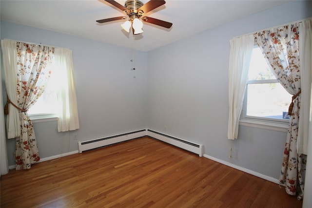 unfurnished room with hardwood / wood-style flooring, ceiling fan, and a baseboard heating unit