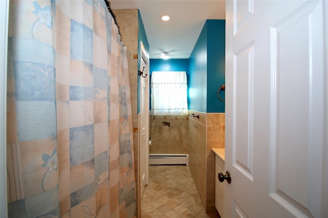 bathroom featuring baseboard heating, curtained shower, and tile walls