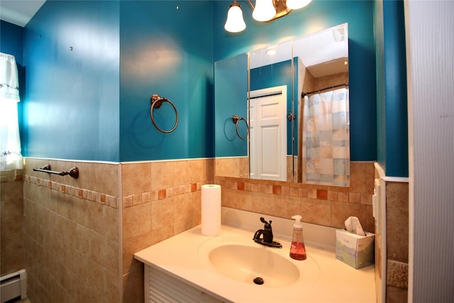 bathroom featuring baseboard heating, vanity, and tile walls