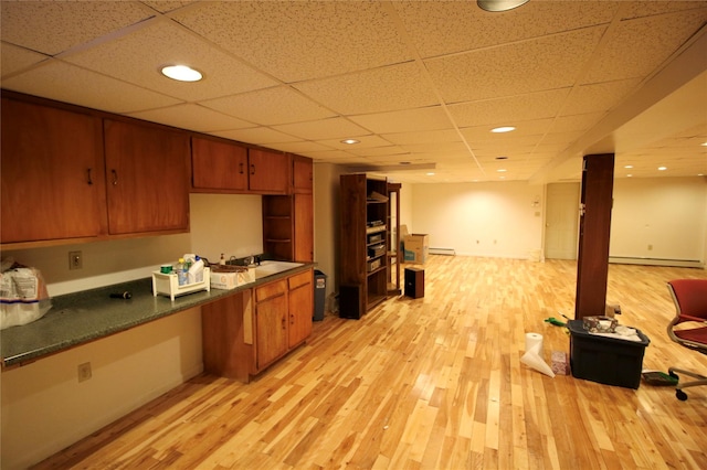 kitchen featuring a drop ceiling, light hardwood / wood-style floors, baseboard heating, and sink