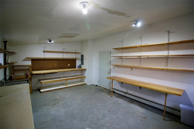 basement featuring baseboard heating, a workshop area, and electric panel