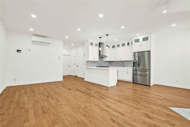 2273 E 27th St, Brooklyn, NY 11229 - kitchen featuring stainless steel refrigerator with ice dispenser, wall chimney range hood, tasteful backsplash, a wall mounted air conditioner, and light countertops