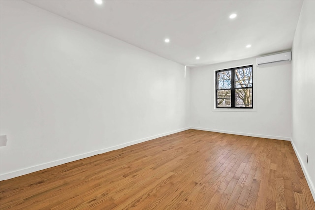 spare room with light hardwood / wood-style flooring and a wall mounted AC