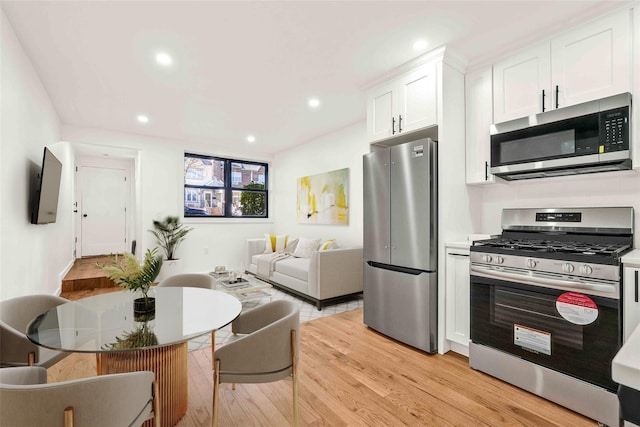 2273 E 27th St, Brooklyn, NY 11229 - kitchen featuring appliances with stainless steel finishes, light wood finished floors, white cabinets, open floor plan, and recessed lighting