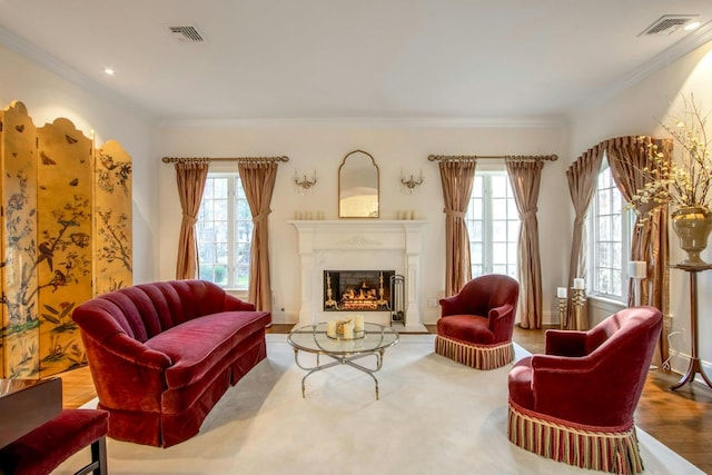 living area featuring hardwood / wood-style flooring, crown molding, and a wealth of natural light