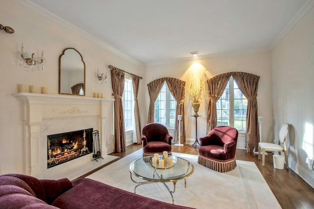 sitting room featuring crown molding, a high end fireplace, and wood-type flooring