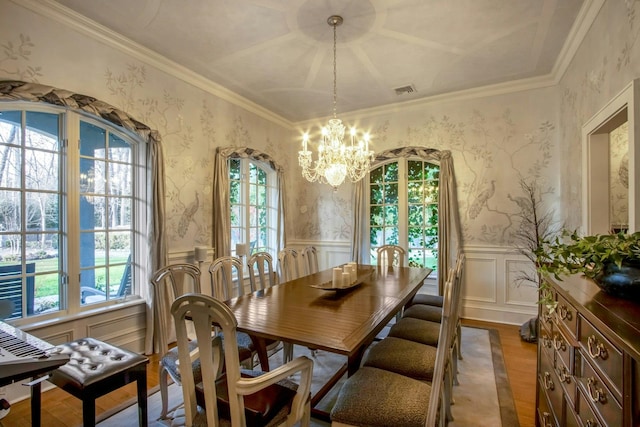 dining space featuring hardwood / wood-style floors, a notable chandelier, and ornamental molding