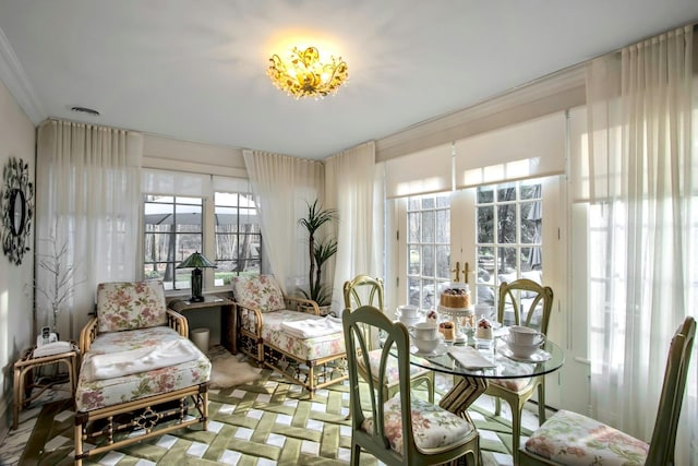 sitting room with ornamental molding and french doors