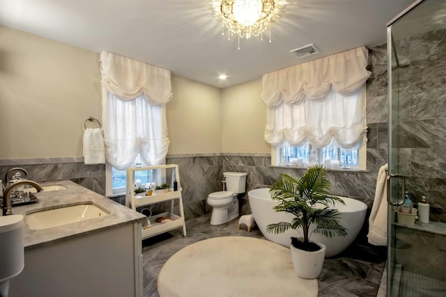 full bathroom featuring toilet, vanity, separate shower and tub, and plenty of natural light