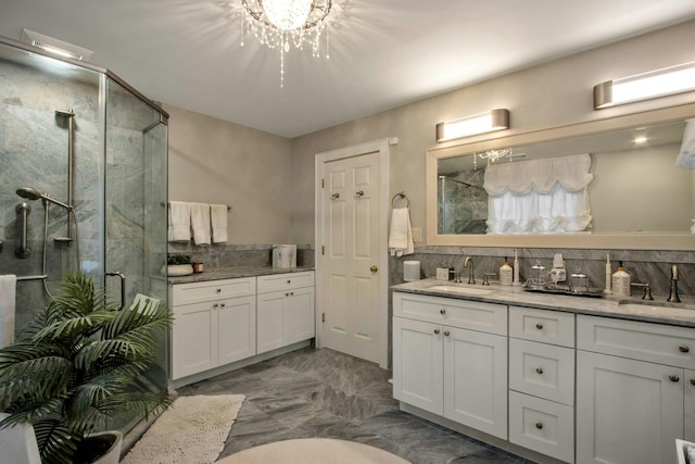 bathroom with decorative backsplash, vanity, an enclosed shower, and a notable chandelier