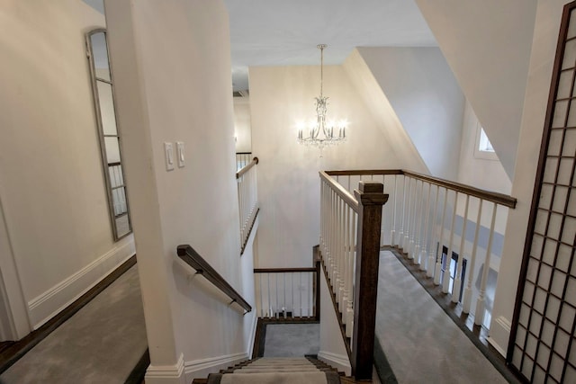 stairway with carpet floors and a chandelier