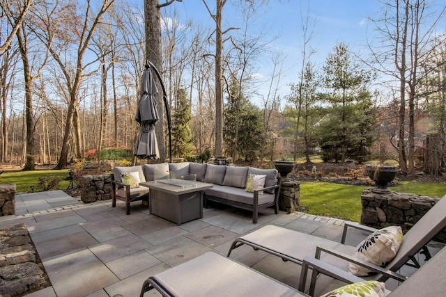 view of patio with an outdoor living space with a fire pit