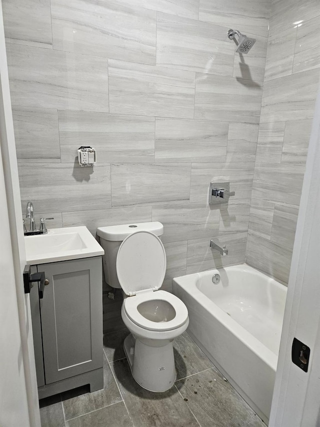 full bathroom with washtub / shower combination, vanity, toilet, and tile walls