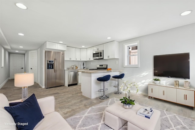 living room with sink and light hardwood / wood-style flooring