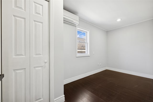 unfurnished room featuring dark hardwood / wood-style floors, a wall unit AC, and crown molding