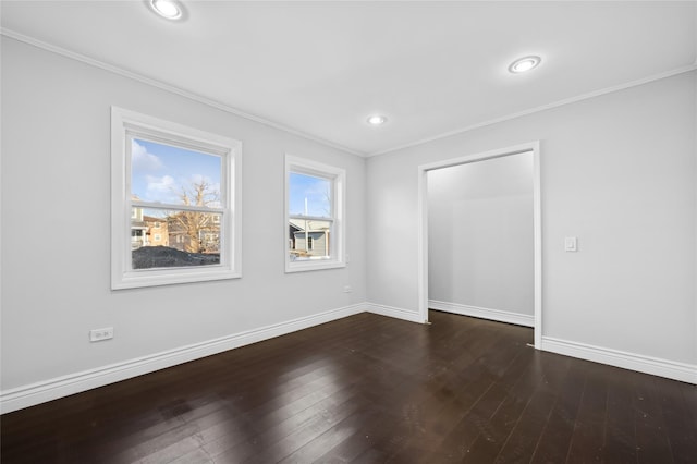 spare room with crown molding and dark wood-type flooring