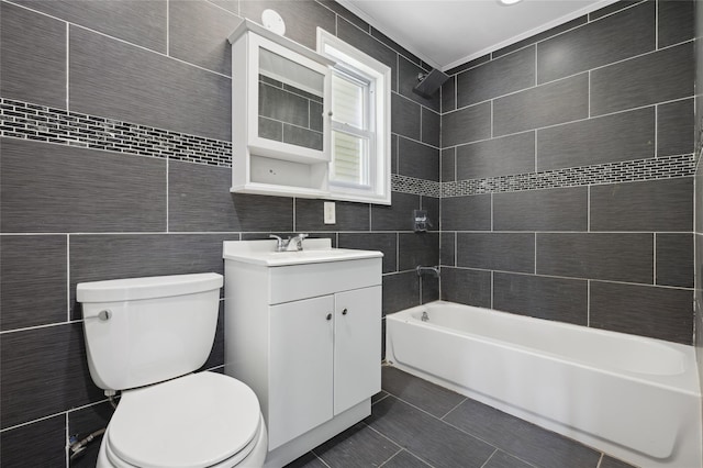 full bathroom featuring shower / bathing tub combination, vanity, toilet, and tile walls