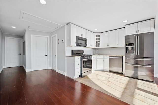 kitchen featuring light stone counters, white cabinets, dark wood-type flooring, and appliances with stainless steel finishes