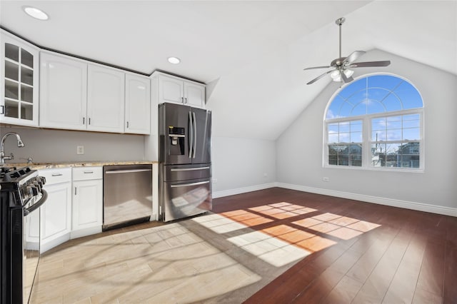 kitchen featuring ceiling fan, light hardwood / wood-style floors, appliances with stainless steel finishes, and vaulted ceiling