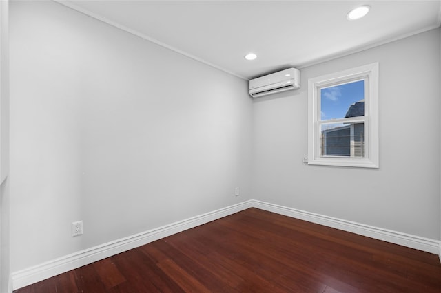 empty room with wood-type flooring, crown molding, and a wall mounted AC