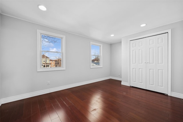 unfurnished bedroom featuring a closet and dark hardwood / wood-style floors